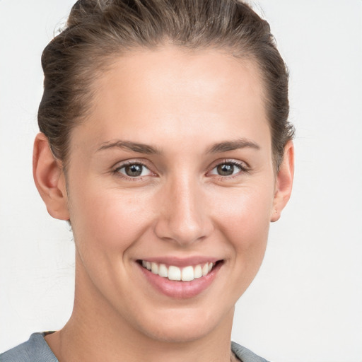 Joyful white young-adult female with short  brown hair and grey eyes