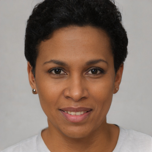 Joyful black young-adult female with short  black hair and brown eyes