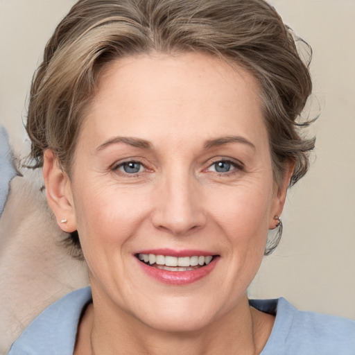 Joyful white adult female with medium  brown hair and grey eyes