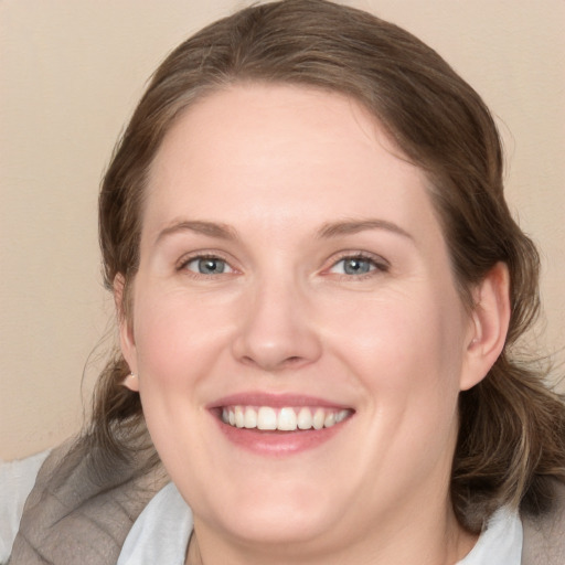 Joyful white young-adult female with medium  brown hair and blue eyes