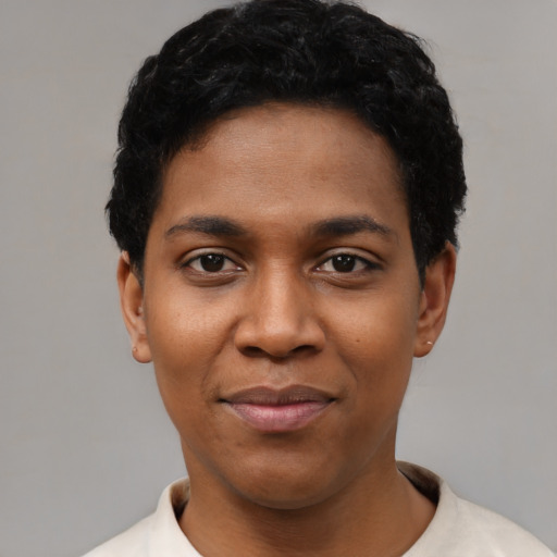 Joyful black young-adult female with short  black hair and brown eyes