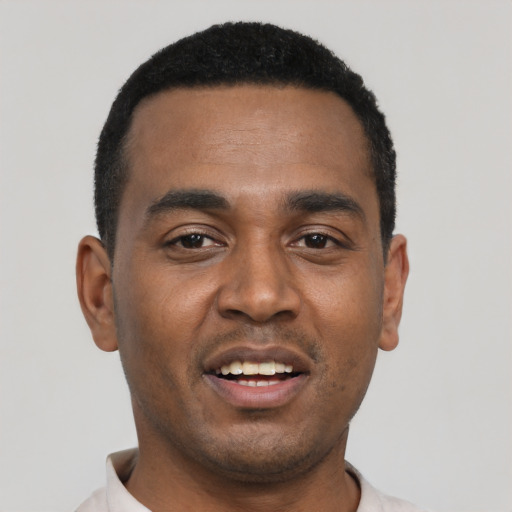 Joyful black young-adult male with short  black hair and brown eyes