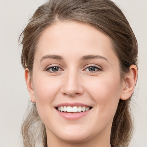 Joyful white young-adult female with long  brown hair and grey eyes