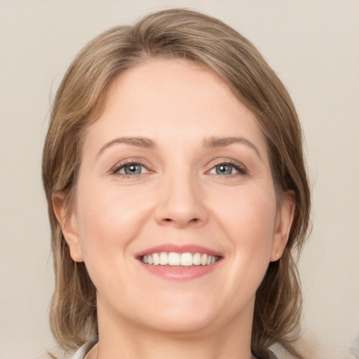 Joyful white young-adult female with medium  brown hair and grey eyes