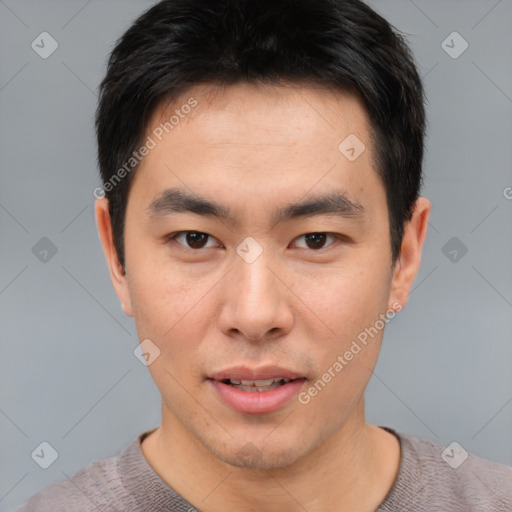 Joyful asian young-adult male with short  brown hair and brown eyes