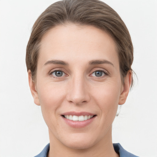 Joyful white young-adult female with medium  brown hair and grey eyes