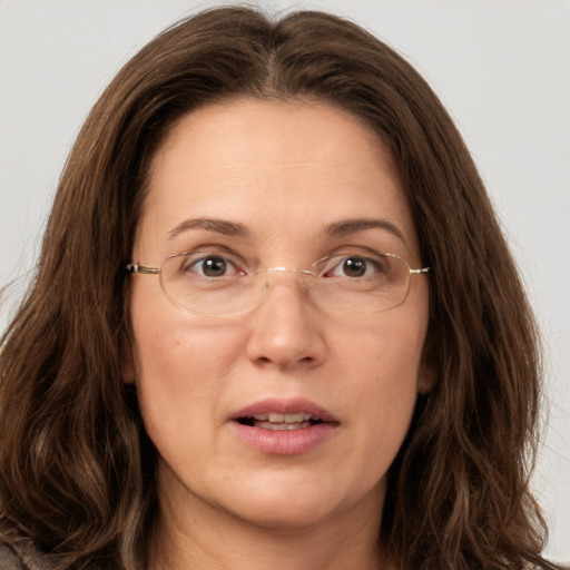 Joyful white adult female with long  brown hair and grey eyes