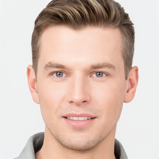 Joyful white young-adult male with short  brown hair and grey eyes