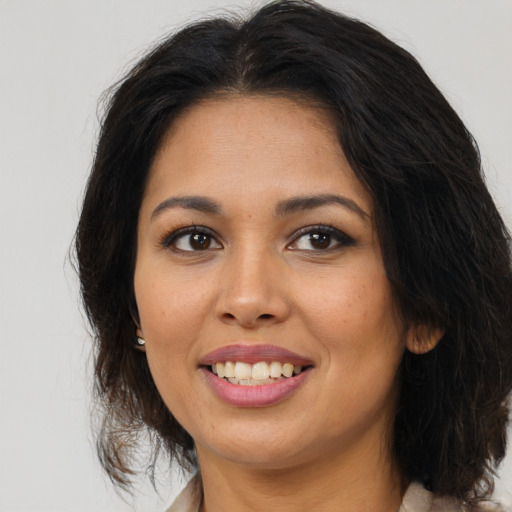 Joyful latino young-adult female with medium  brown hair and brown eyes
