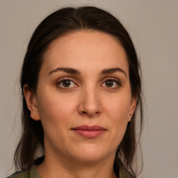 Joyful white young-adult female with long  brown hair and green eyes