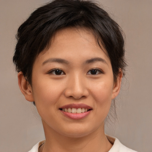 Joyful asian young-adult female with short  brown hair and brown eyes