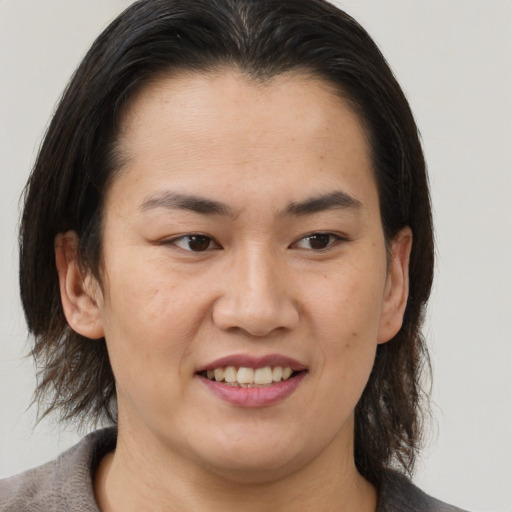 Joyful asian young-adult female with medium  brown hair and brown eyes