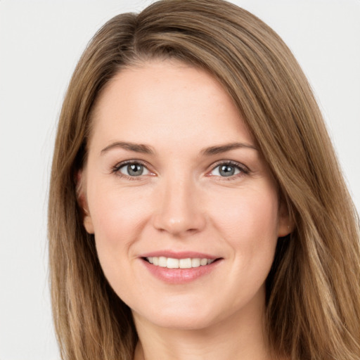 Joyful white young-adult female with long  brown hair and green eyes