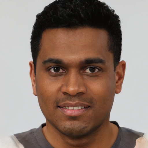 Joyful black young-adult male with short  black hair and brown eyes