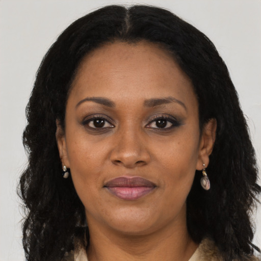 Joyful black adult female with long  black hair and brown eyes