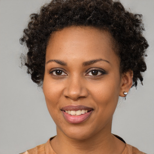 Joyful black young-adult female with short  brown hair and brown eyes
