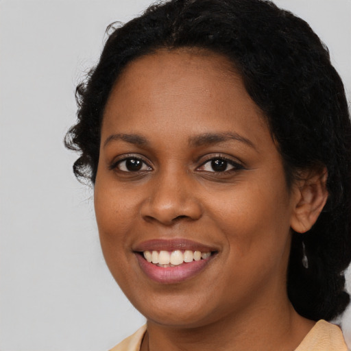 Joyful black young-adult female with medium  brown hair and brown eyes