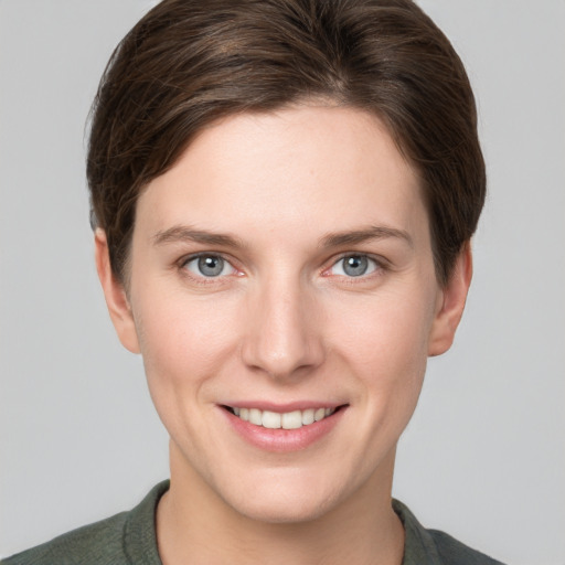 Joyful white young-adult female with short  brown hair and grey eyes