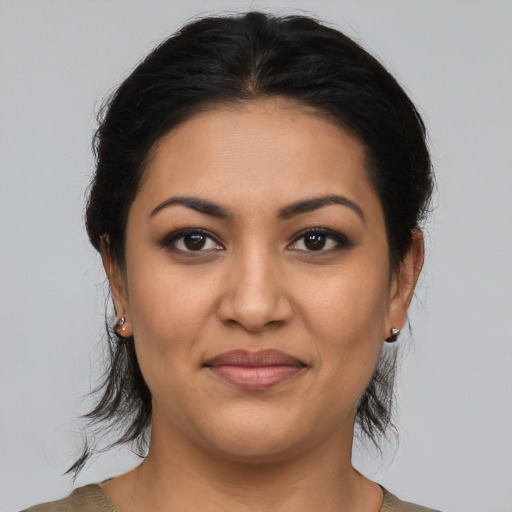 Joyful latino young-adult female with medium  brown hair and brown eyes