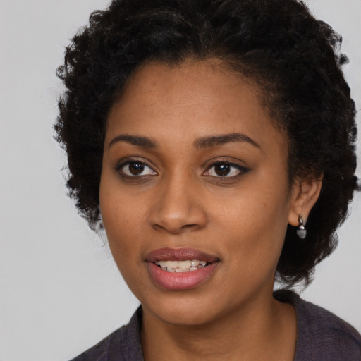 Joyful black young-adult female with long  brown hair and brown eyes