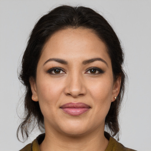 Joyful latino young-adult female with medium  brown hair and brown eyes