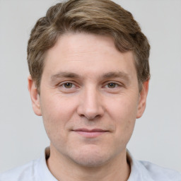 Joyful white young-adult male with short  brown hair and grey eyes