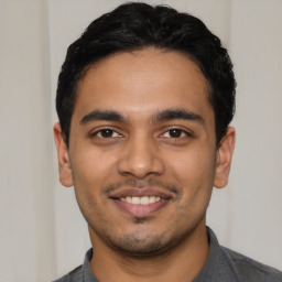 Joyful latino young-adult male with short  black hair and brown eyes