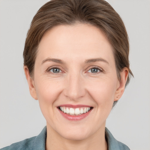 Joyful white young-adult female with short  brown hair and grey eyes