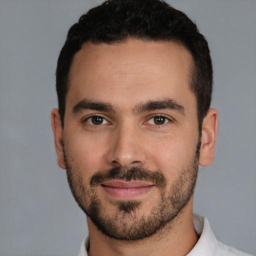 Joyful white young-adult male with short  black hair and brown eyes