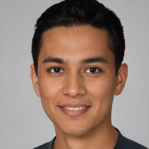 Joyful latino young-adult male with short  black hair and brown eyes