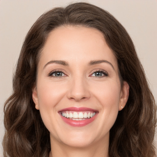 Joyful white young-adult female with long  brown hair and brown eyes