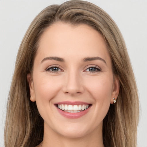 Joyful white young-adult female with long  brown hair and grey eyes