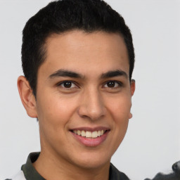 Joyful latino young-adult male with short  brown hair and brown eyes