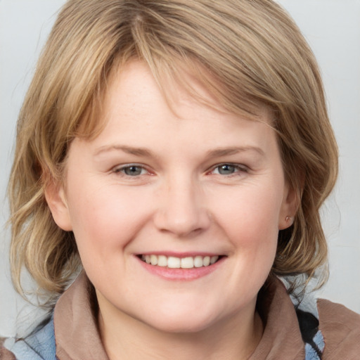 Joyful white young-adult female with medium  brown hair and blue eyes