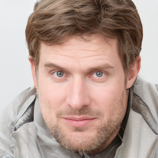 Joyful white adult male with short  brown hair and blue eyes