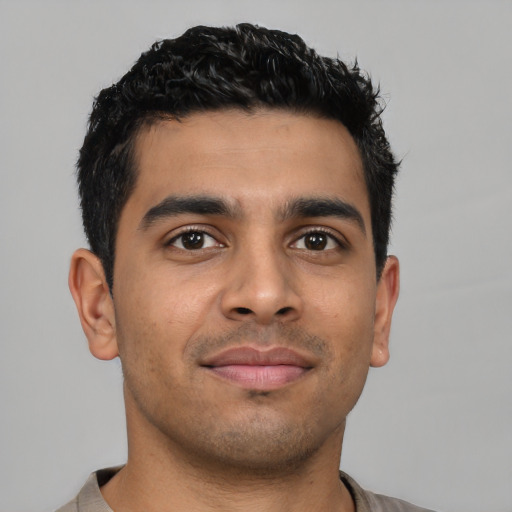 Joyful latino young-adult male with short  brown hair and brown eyes