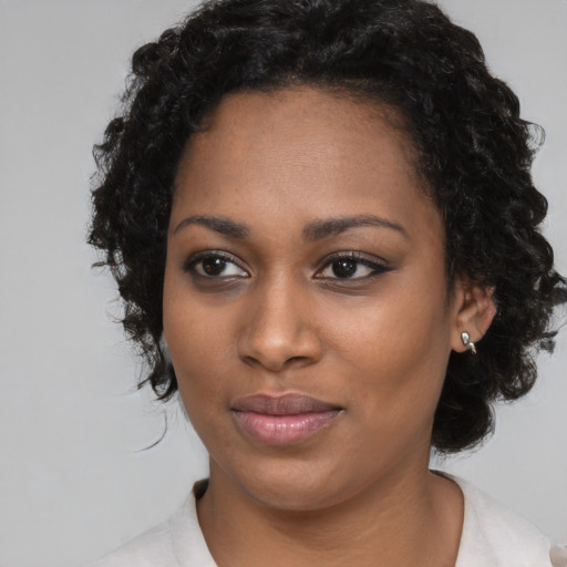 Joyful black young-adult female with medium  black hair and brown eyes