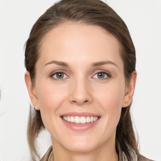 Joyful white young-adult female with long  brown hair and grey eyes