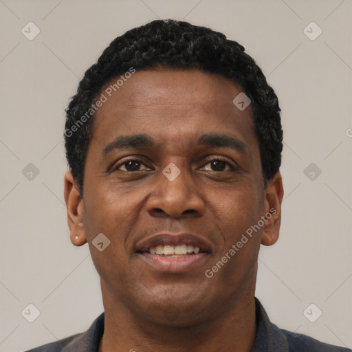 Joyful black young-adult male with short  black hair and brown eyes
