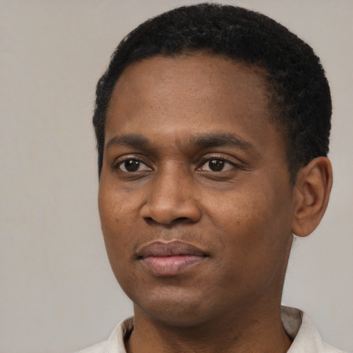 Joyful black young-adult male with short  black hair and brown eyes