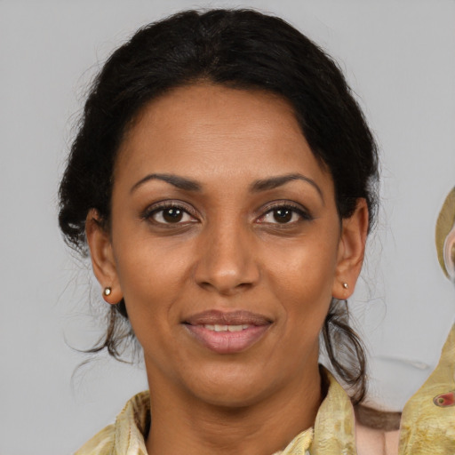 Joyful black adult female with medium  brown hair and brown eyes