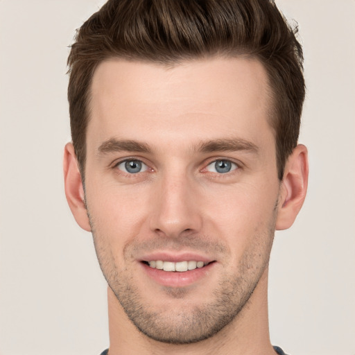 Joyful white young-adult male with short  brown hair and grey eyes