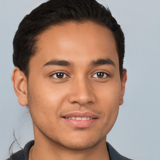 Joyful latino young-adult male with short  brown hair and brown eyes