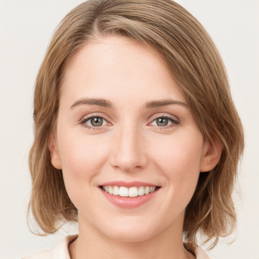 Joyful white young-adult female with medium  brown hair and green eyes