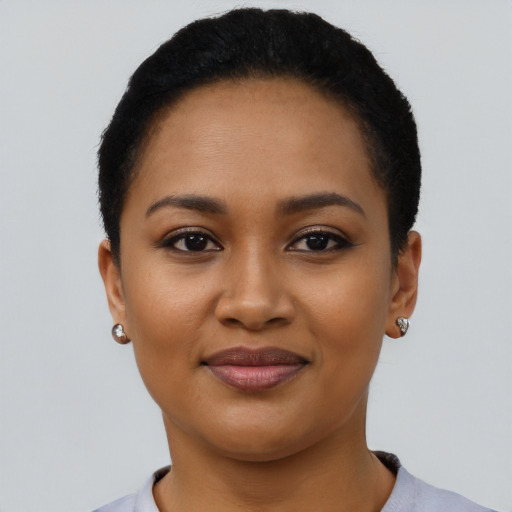 Joyful latino young-adult female with short  black hair and brown eyes