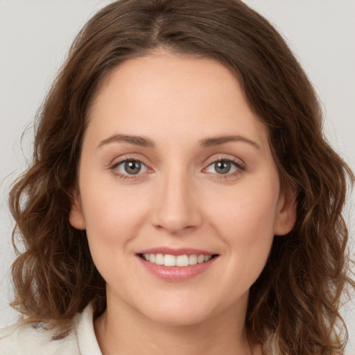 Joyful white young-adult female with long  brown hair and green eyes