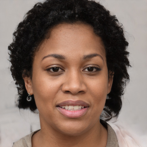 Joyful black young-adult female with short  brown hair and brown eyes
