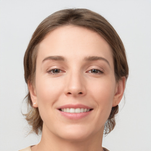 Joyful white young-adult female with medium  brown hair and grey eyes