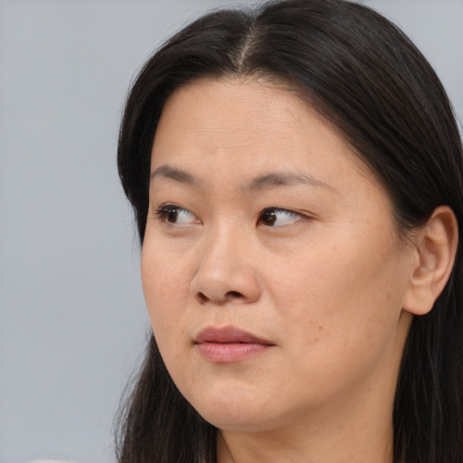 Neutral asian adult female with long  brown hair and brown eyes