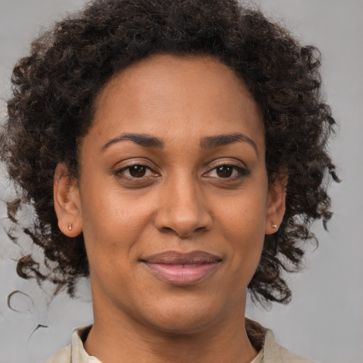 Joyful black adult female with medium  brown hair and brown eyes